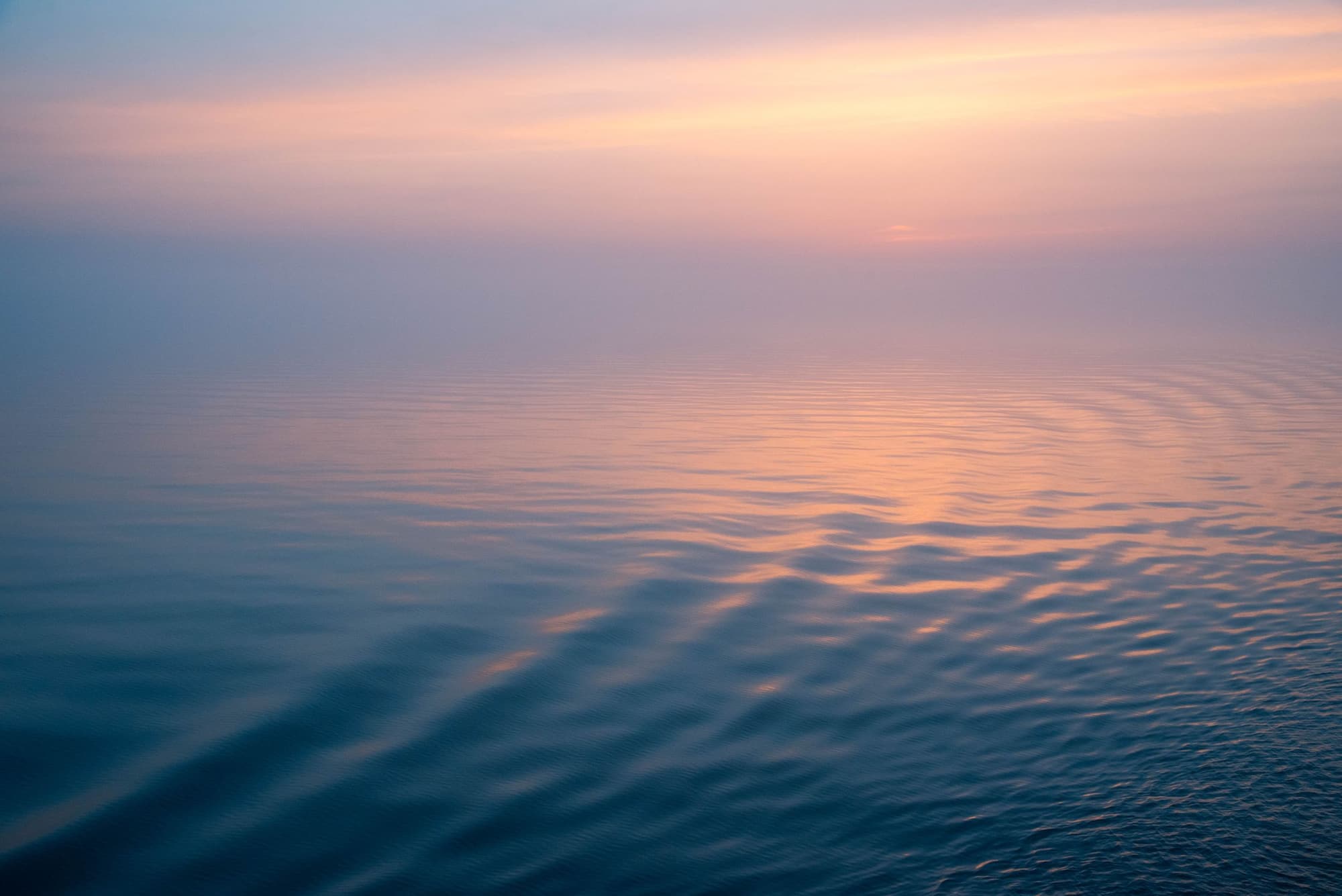 Calm sea at dawn under a pink sky